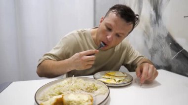 Genç bir adam akşam yemeğinde lahana salatasıyla omlet yer. Evde ev yemeği var..
