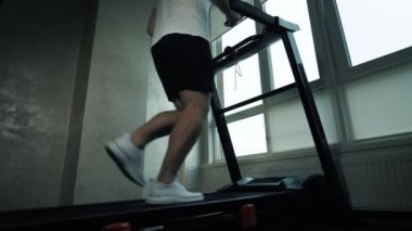 Koşu bandında kardiyo antrenmanı. Spor salonunda elektrikli bisikletle koşmak, ağır çekim.