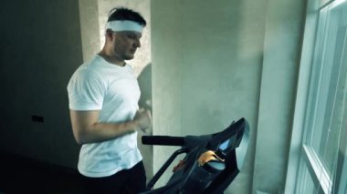 Koşu bandında kardiyo antrenmanı. Spor salonunda elektrikli bisikletle koşmak, ağır çekim..