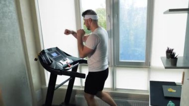 Koşu bandında çalışan bir kardiyo eğitimi, elleriyle boks yapan bir sporcu. yavaş çekim.