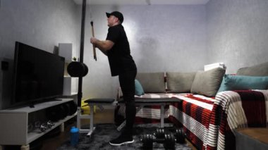 Simülatörde ev çalışması, kol pompası. Genç bir sporcu kollarını evde çalıştırıyor. Yavaş çekim