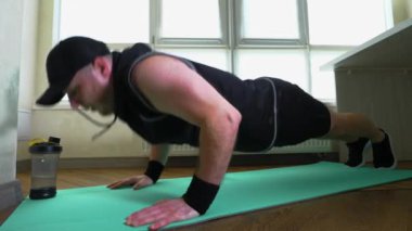 Spor, şınav, spor paspası. Spor giyim eğitimi alan genç bir adam. Yavaş çekim.