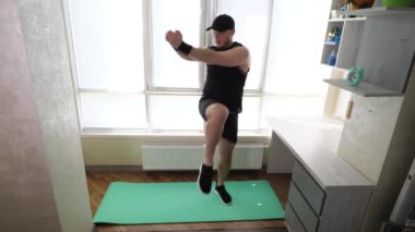Eğitimde karın kaslarınızı şişirin, dizinizi vücudunuza doğru bükerek bacaklarınızı kaldırın. Evde spor salonunun paspası üzerinde çalışıyorum. Yavaş çekim