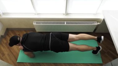 Fitness minderinde kardiyo çalışması. Evde yağ yakma egzersizi, vücudunu kaldırmış yatarken egzersiz. Yavaş çekim.