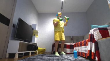 Elinde dambıllarla boks yap. Kardiyo çalışması. Bir evin içinde antrenman eğitimi aldım. Genç bir sporcu. Yavaş çekim