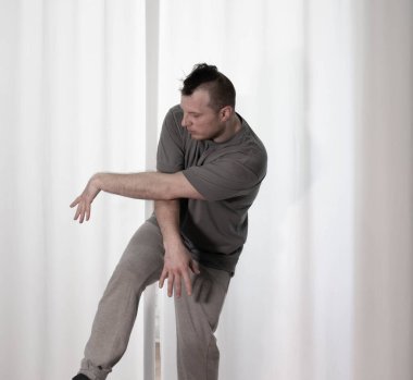 Hareketli dans, hip-hop tarzı giyinmiş bir adamın pozu. Antrenmandaki spor dansçısı poz veriyor. Evde dans eğitimi..