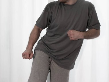 Hareketli dans, hip-hop tarzı giyinmiş bir adamın pozu. Antrenmandaki spor dansçısı poz veriyor. Evde dans eğitimi..