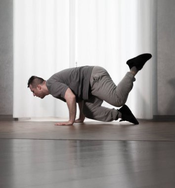Hareketli dans, hip-hop tarzı giyinmiş bir adamın pozu. Antrenmandaki spor dansçısı poz veriyor. Evde dans eğitimi..