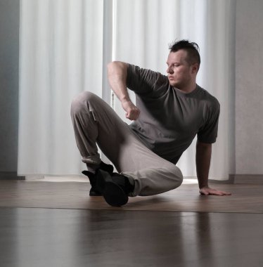 Hareketli dans, hip-hop tarzı giyinmiş bir adamın pozu. Antrenmandaki spor dansçısı poz veriyor. Evde dans eğitimi..