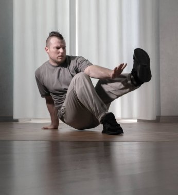 Hareketli dans, hip-hop tarzı giyinmiş bir adamın pozu. Antrenmandaki spor dansçısı poz veriyor. Evde dans eğitimi..