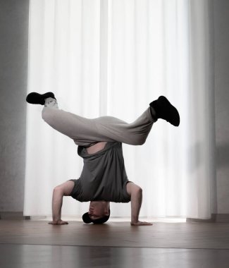 Hareketli dans, hip-hop tarzı giyinmiş bir adamın pozu. Antrenmandaki spor dansçısı poz veriyor. Evde dans eğitimi..