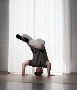 Hareketli dans, hip-hop tarzı giyinmiş bir adamın pozu. Antrenmandaki spor dansçısı poz veriyor. Evde dans eğitimi..