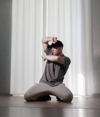 Hareketli dans, hip-hop tarzı giyinmiş bir adamın pozu. Antrenmandaki spor dansçısı poz veriyor. Evde dans eğitimi..