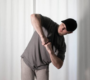 Hareketli dans, hip-hop tarzı giyinmiş bir adamın pozu. Antrenmandaki spor dansçısı poz veriyor. Evde dans eğitimi..