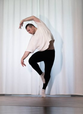 Yoga pozisyonunda ev çalışması. Bir adam kolları ve bacaklarıyla spor dansı egzersizleri yapıyor. Pilates esneme