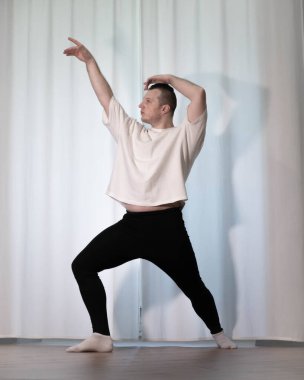 Evde yoga pozu egzersizi. Kolları ve bacaklarıyla spor egzersizleri yapan bir adam. Erkek sporcu geriniyor..