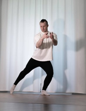 Evde yoga pozu egzersizi. Kolları ve bacaklarıyla spor egzersizleri yapan bir adam. Erkek sporcu geriniyor..