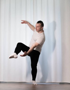 Evde yoga pozu egzersizi. Kolları ve bacaklarıyla spor egzersizleri yapan bir adam. Erkek sporcu geriniyor..