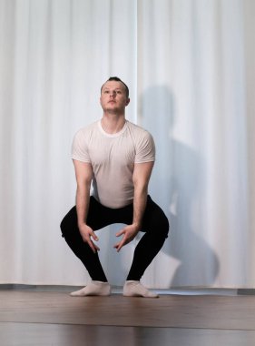 Evde yoga pozu egzersizi. Kolları ve bacaklarıyla spor egzersizleri yapan bir adam. Erkek sporcu geriniyor..