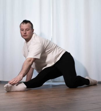 Evde yoga pozu egzersizi. Kolları ve bacaklarıyla spor egzersizleri yapan bir adam. Erkek sporcu geriniyor..