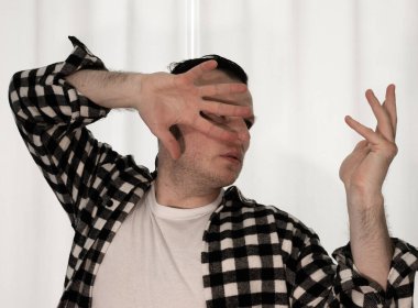 Beyaz arka planda dans eden genç adam. Ekose gömlekle modern dans. Spor plastik hareketler kollar, bacaklar ve gövde.