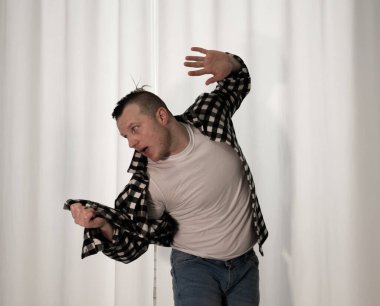 Beyaz arka planda dans eden genç adam. Ekose gömlekle modern dans. Spor plastik hareketler kollar, bacaklar ve gövde.