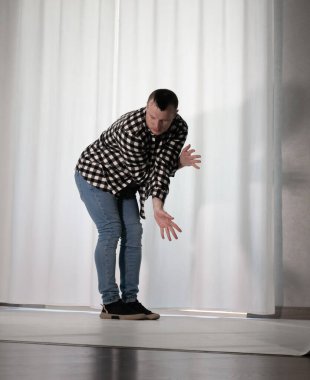 Beyaz arka planda dans eden genç adam. Ekose gömlekle modern dans. Spor plastik hareketler kollar, bacaklar ve gövde.