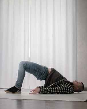 Beyaz arka planda dans eden genç adam. Ekose gömlekle modern dans. Spor plastik hareketler kollar, bacaklar ve gövde.