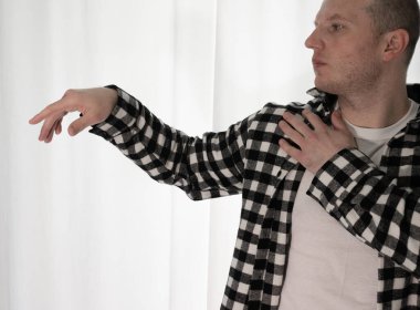 Beyaz arka planda dans eden genç adam. Ekose gömlekle modern dans. Spor plastik hareketler kollar, bacaklar ve gövde.