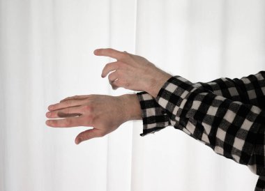 Beyaz arka planda dans eden genç adam. Ekose gömlekle modern dans. Spor plastik hareketler kollar, bacaklar ve gövde.