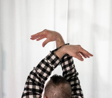 Beyaz arka planda dans eden genç adam. Ekose gömlekle modern dans. Spor plastik hareketler kollar, bacaklar ve gövde.