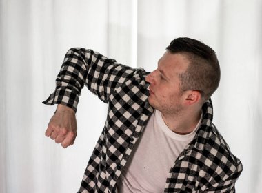 Beyaz arka planda dans eden genç adam. Ekose gömlekle modern dans. Spor plastik hareketler kollar, bacaklar ve gövde.