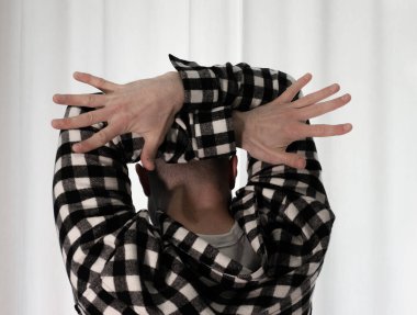 Beyaz arka planda dans eden genç adam. Ekose gömlekle modern dans. Spor plastik hareketler kollar, bacaklar ve gövde.