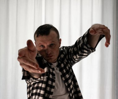 Beyaz arka planda dans eden genç adam. Ekose gömlekle modern dans. Spor plastik hareketler kollar, bacaklar ve gövde.