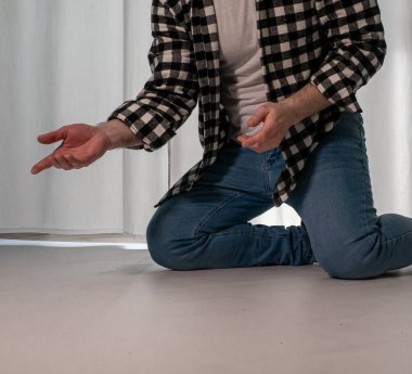 Beyaz arka planda dans eden genç adam. Ekose gömlekle modern dans. Spor plastik hareketler kollar, bacaklar ve gövde.