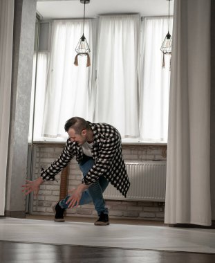 Beyaz arka planda dans eden genç adam. Ekose gömlekle modern dans. Spor plastik hareketler kollar, bacaklar ve gövde.