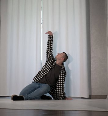 Beyaz arka planda dans eden genç adam. Ekose gömlekle modern dans. Spor plastik hareketler kollar, bacaklar ve gövde.