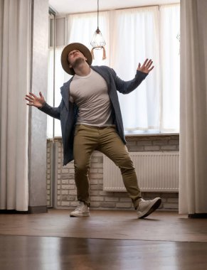 Genç dansçı poz veriyor. Gündelik kıyafetlerle modern bir dans sergileyen bir adam..