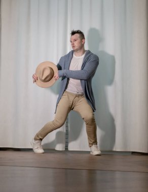 Genç dansçı poz veriyor. Gündelik kıyafetlerle modern bir dans sergileyen bir adam..
