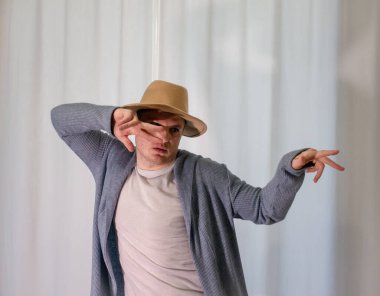 Genç dansçı poz veriyor. Gündelik kıyafetlerle modern bir dans sergileyen bir adam..