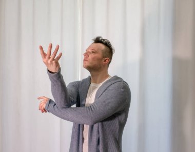 Genç dansçı poz veriyor. Gündelik kıyafetlerle modern bir dans sergileyen bir adam..