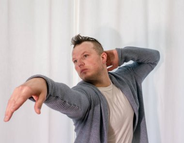 Genç dansçı poz veriyor. Gündelik kıyafetlerle modern bir dans sergileyen bir adam..