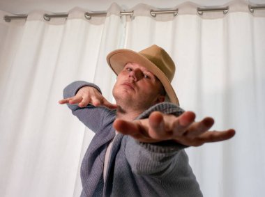 Genç dansçı poz veriyor. Gündelik kıyafetlerle modern bir dans sergileyen bir adam..