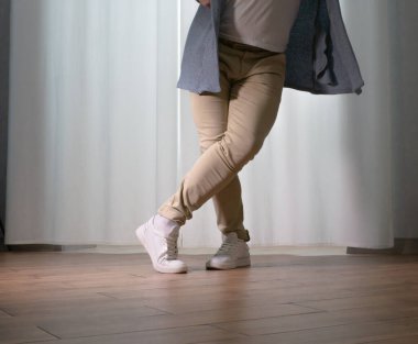 Genç dansçı poz veriyor. Gündelik kıyafetlerle modern bir dans sergileyen bir adam..