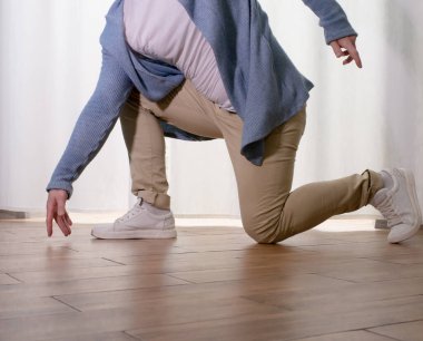 Genç dansçı poz veriyor. Gündelik kıyafetlerle modern bir dans sergileyen bir adam..