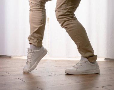 Genç dansçı poz veriyor. Gündelik kıyafetlerle modern bir dans sergileyen bir adam..