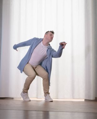 Genç dansçı poz veriyor. Gündelik kıyafetlerle modern bir dans sergileyen bir adam..