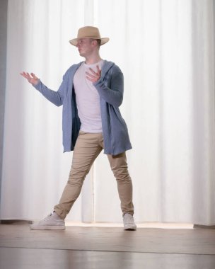 Genç dansçı poz veriyor. Gündelik kıyafetlerle modern bir dans sergileyen bir adam..