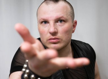 Rock kostümlü bir adam dans figürleri sergiler. Kafasında mohawk olan metal bir adam. Hareket eden adam ve dans eden kollar ve bacaklar..