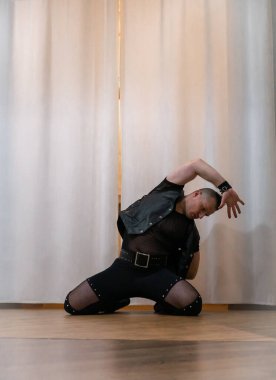 Rock kostümlü bir adam dans figürleri sergiler. Kafasında mohawk olan metal bir adam. Hareket eden adam ve dans eden kollar ve bacaklar..